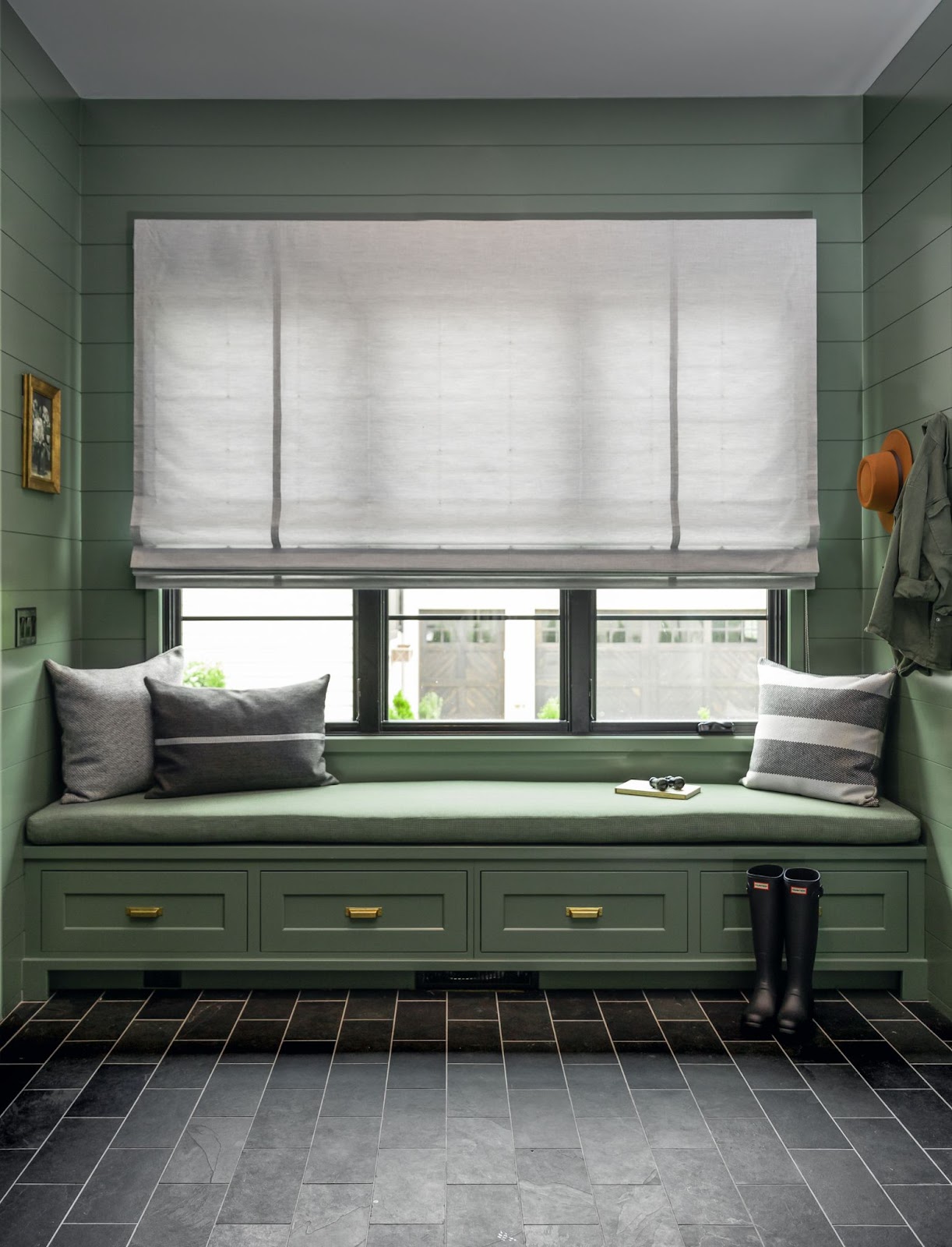 white sunbrella window treatments in a green window bench