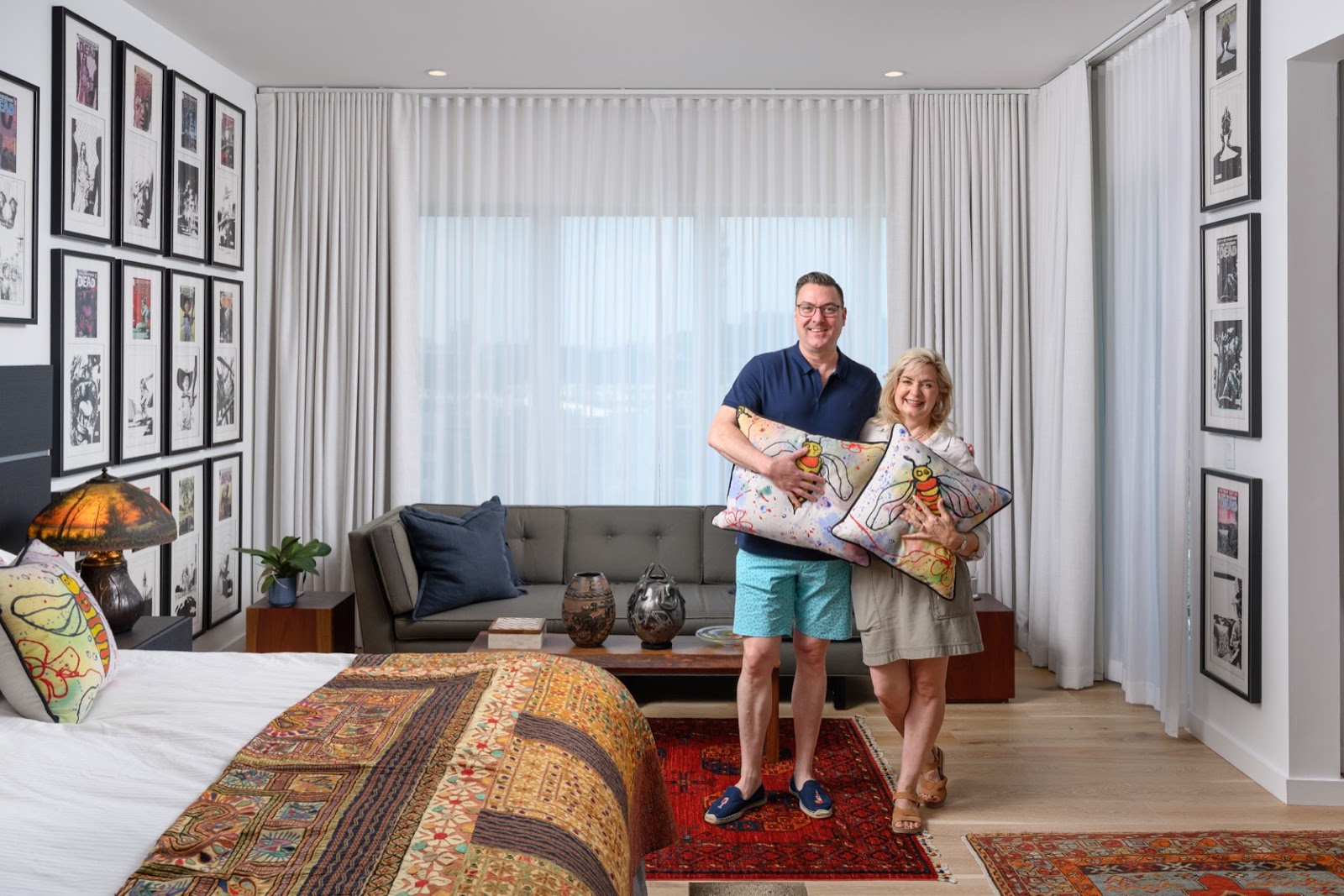 two homeowners standing in front of their ripplefold drapery window in living room